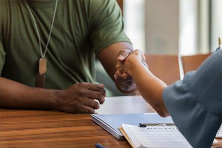 Military student shakes hands in a meeting